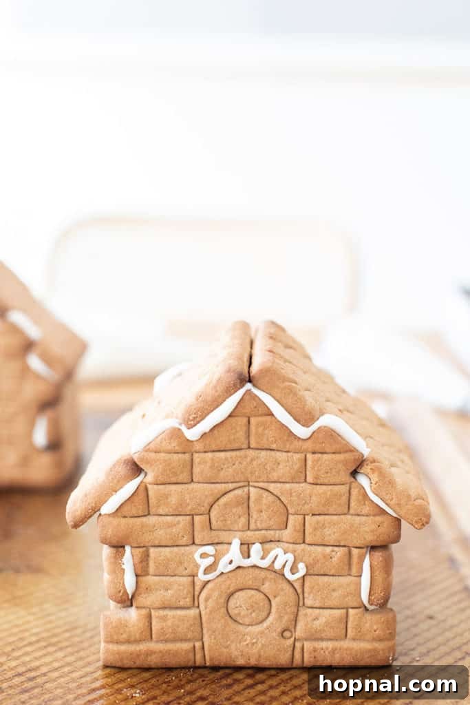 A finished gingerbread house, beautifully adorned with white icing details.