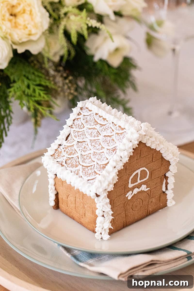 A delightful mini gingerbread house with the name 'Zan' expertly written in white frosting.