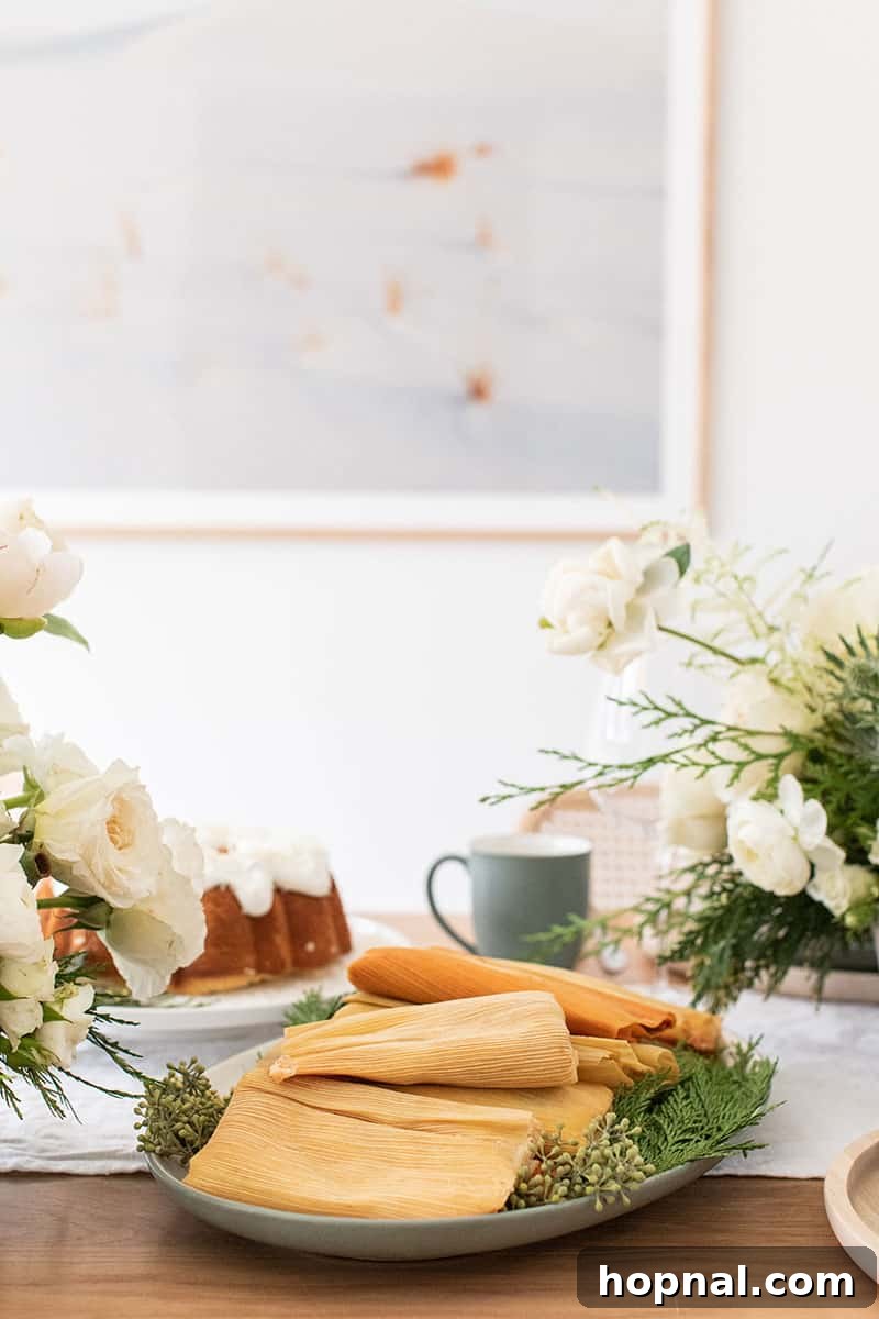 Delicious Christmas Eve Tamales arranged on a festive table setting with holiday greenery.