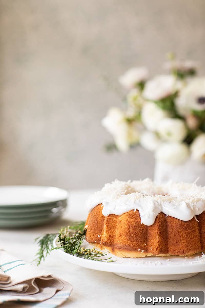 A classic southern coconut bundt cake proudly displayed on an elegant footed cake stand, perfect for Christmas Day celebrations.