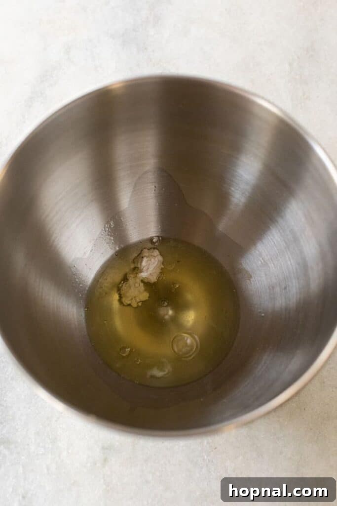 Close-up of egg whites and cream of tartar being combined in a mixing bowl.