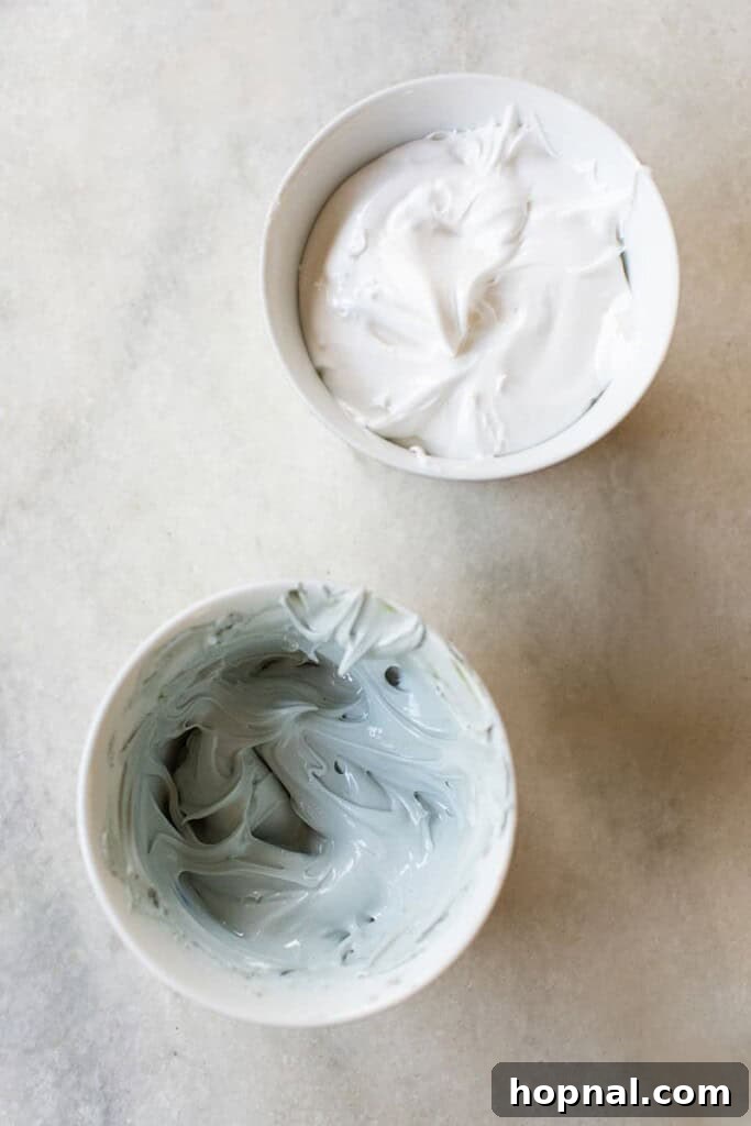 Bowls of homemade gingerbread house icing in white and blue, showing different coloring options.
