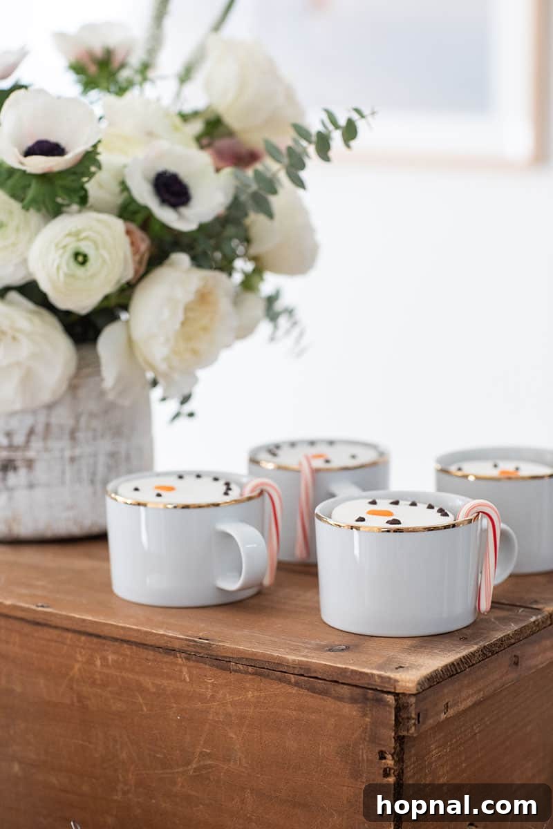 The Ultimate Guide to a Showstopping Christmas Dessert Display 11 White and gold cups overflowing with rich hot chocolate, garnished with festive candy canes.