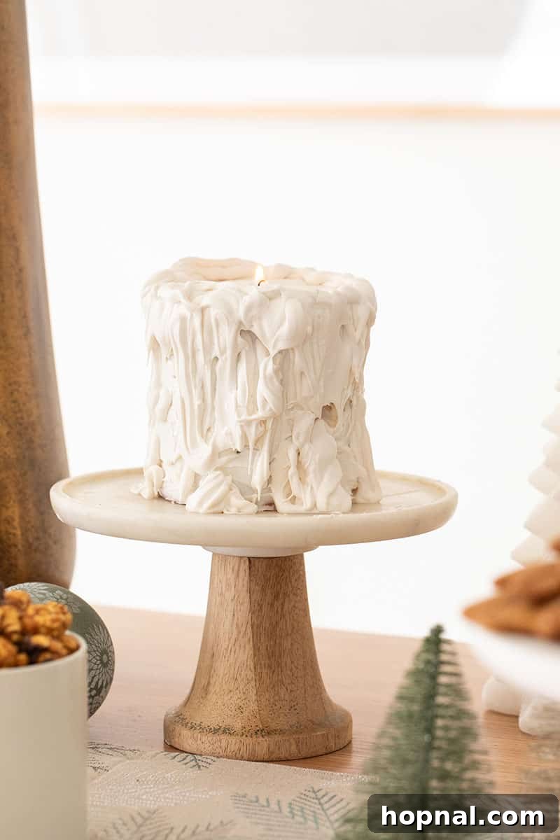 The Ultimate Guide to a Showstopping Christmas Dessert Display 17 A stylish white candle cake, designed to look like a burning candle, adding a unique decorative element to the dessert table.