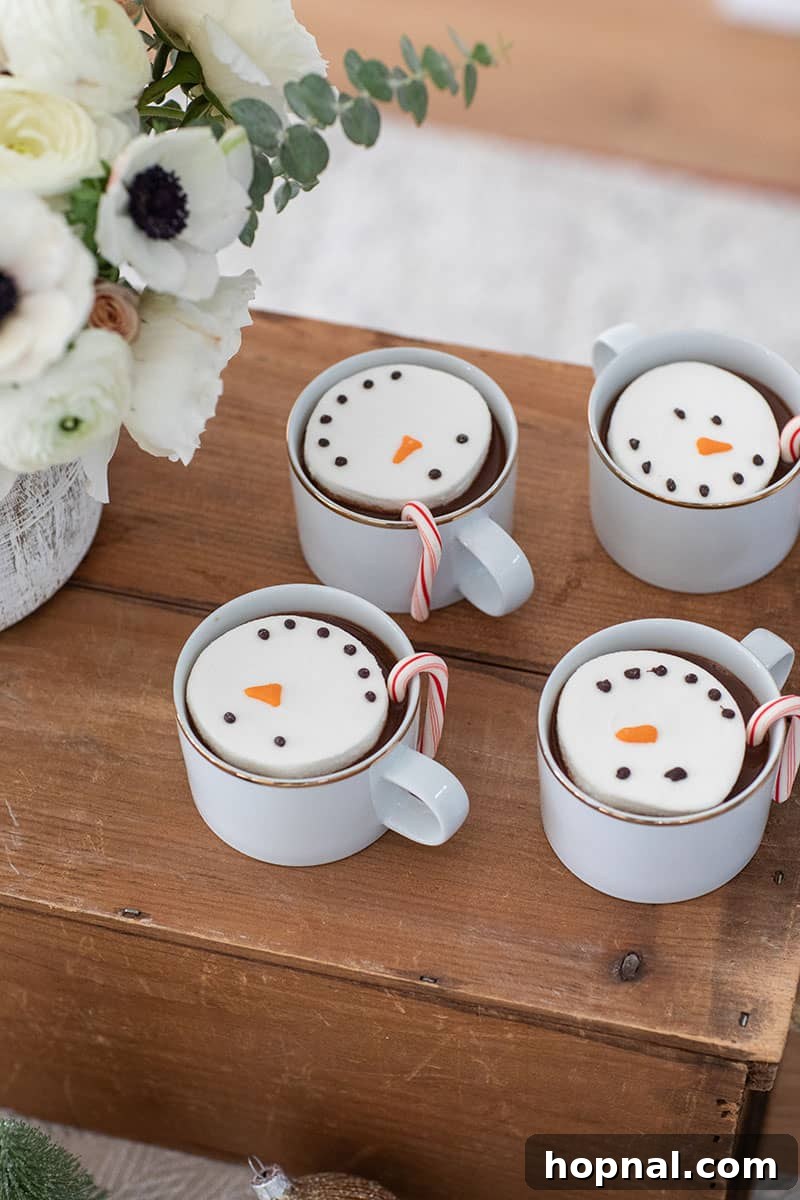 The Ultimate Guide to a Showstopping Christmas Dessert Display 24 Adorable marshmallow snowmen floating in mugs of hot cocoa, creating a festive and inviting treat.