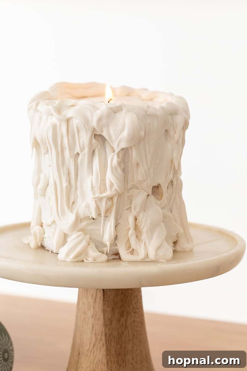 The Ultimate Guide to a Showstopping Christmas Dessert Display 26 A creative white candle drip cake, presented on an elegant marble cake stand, perfect for a festive display.