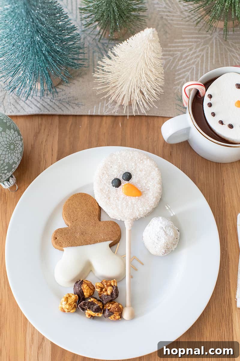 The Ultimate Guide to a Showstopping Christmas Dessert Display 6 Holiday desserts presented on a stylish gold and white plate, including a gingerbread cookie, a snowman cookie, and popcorn.