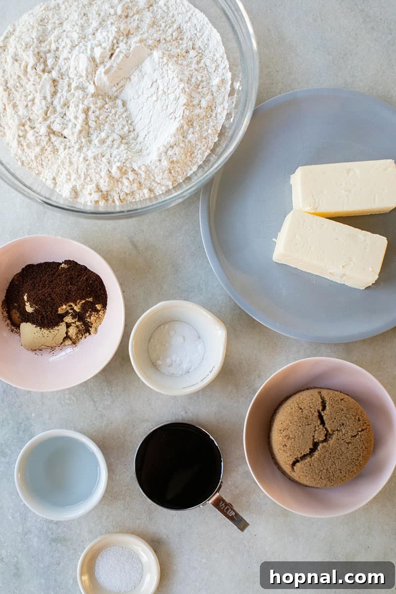 Bowls of essential gingerbread house ingredients: brown sugar, all-purpose flour, rich molasses, softened butter, granulated sugar, baking soda, and a pinch of salt.