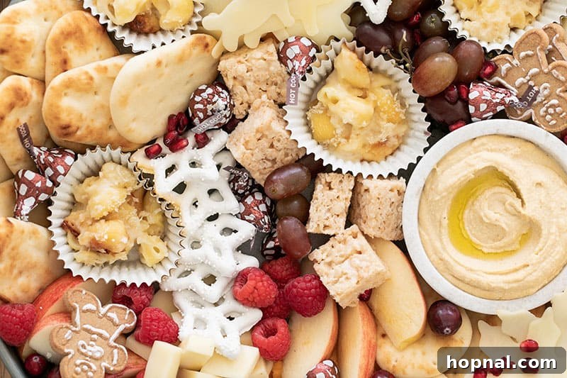 Santa's Snack Tray for Kids 6 A vibrant and wholesome kids' appetizer platter showcasing perfectly toasted pita bread slices, creamy hummus, sweet yogurt-covered pretzels, and a fresh medley of red berries and green grapes, perfect for hungry little ones.