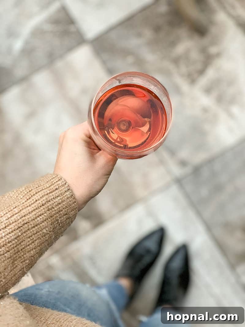 Holding a glass of Rosé in Sonoma County with vineyards in the background
