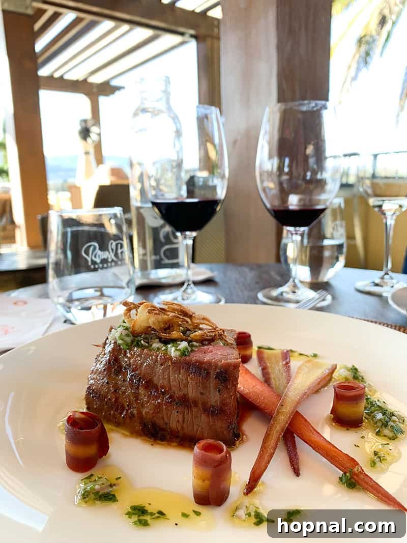 A beautifully presented dish of meat and fresh vegetables on a white plate at Round Pond Napa