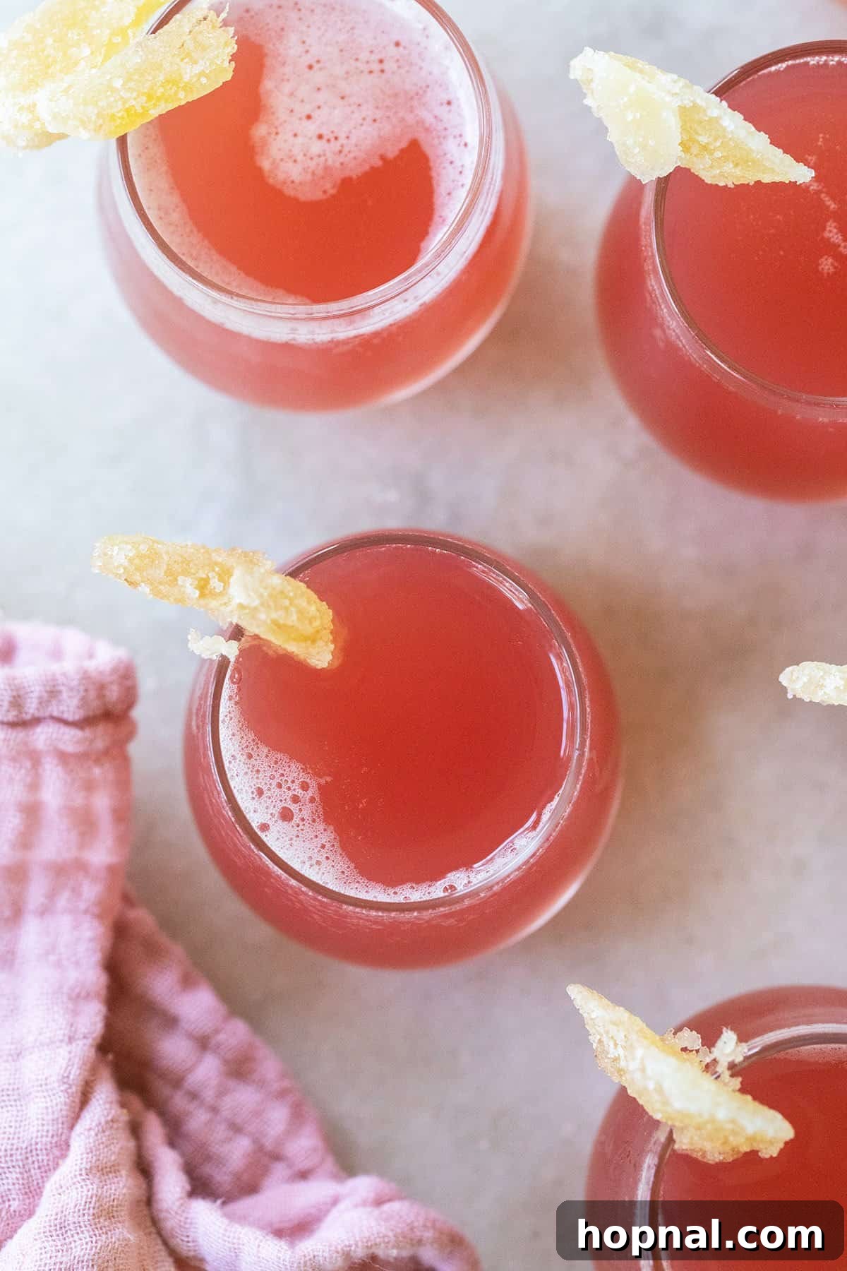 Pink Jolly Rancher shots garnished with candied ginger.