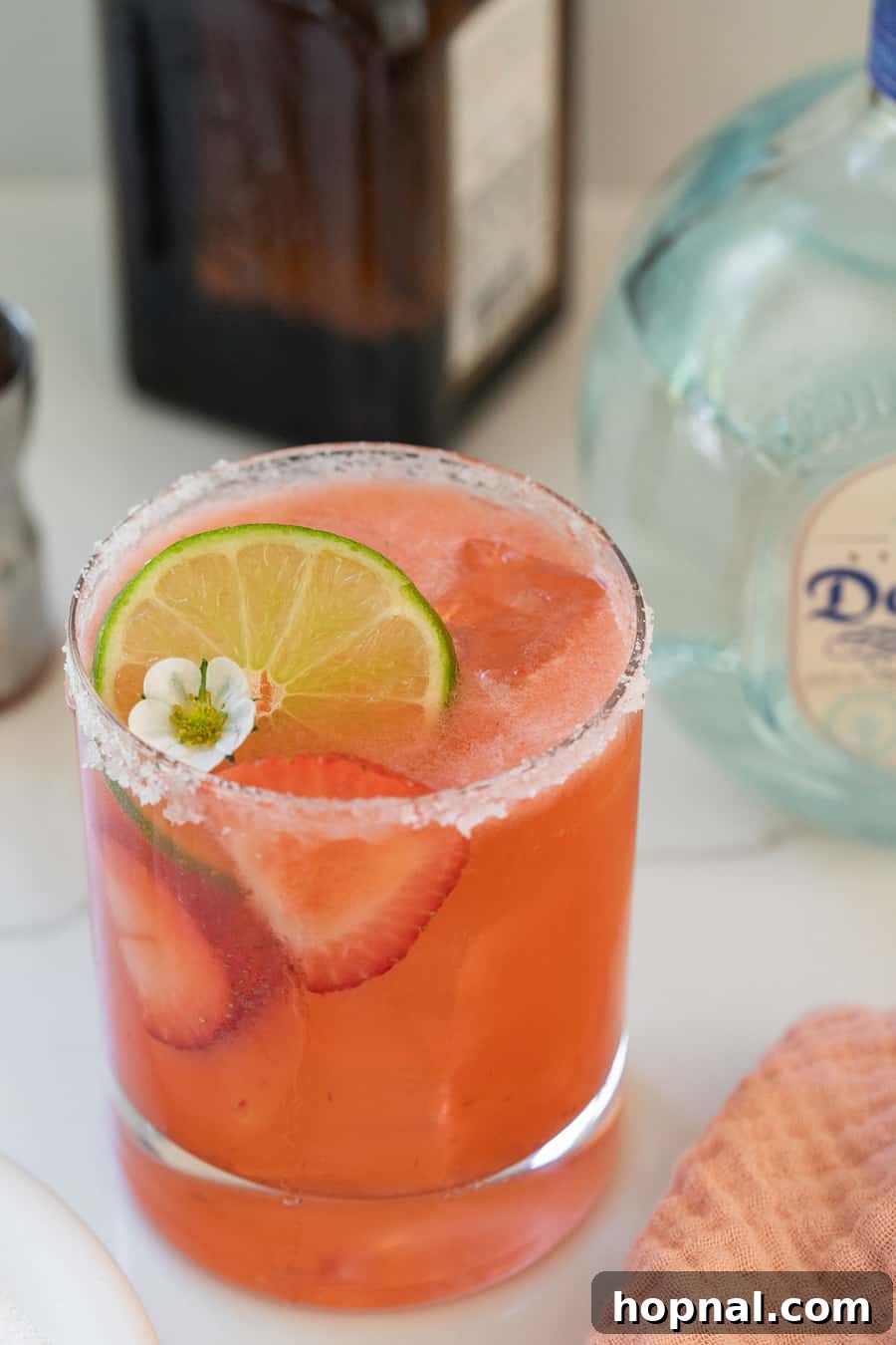 Strawberry margarita recipe, vibrant red with fresh strawberry slices.