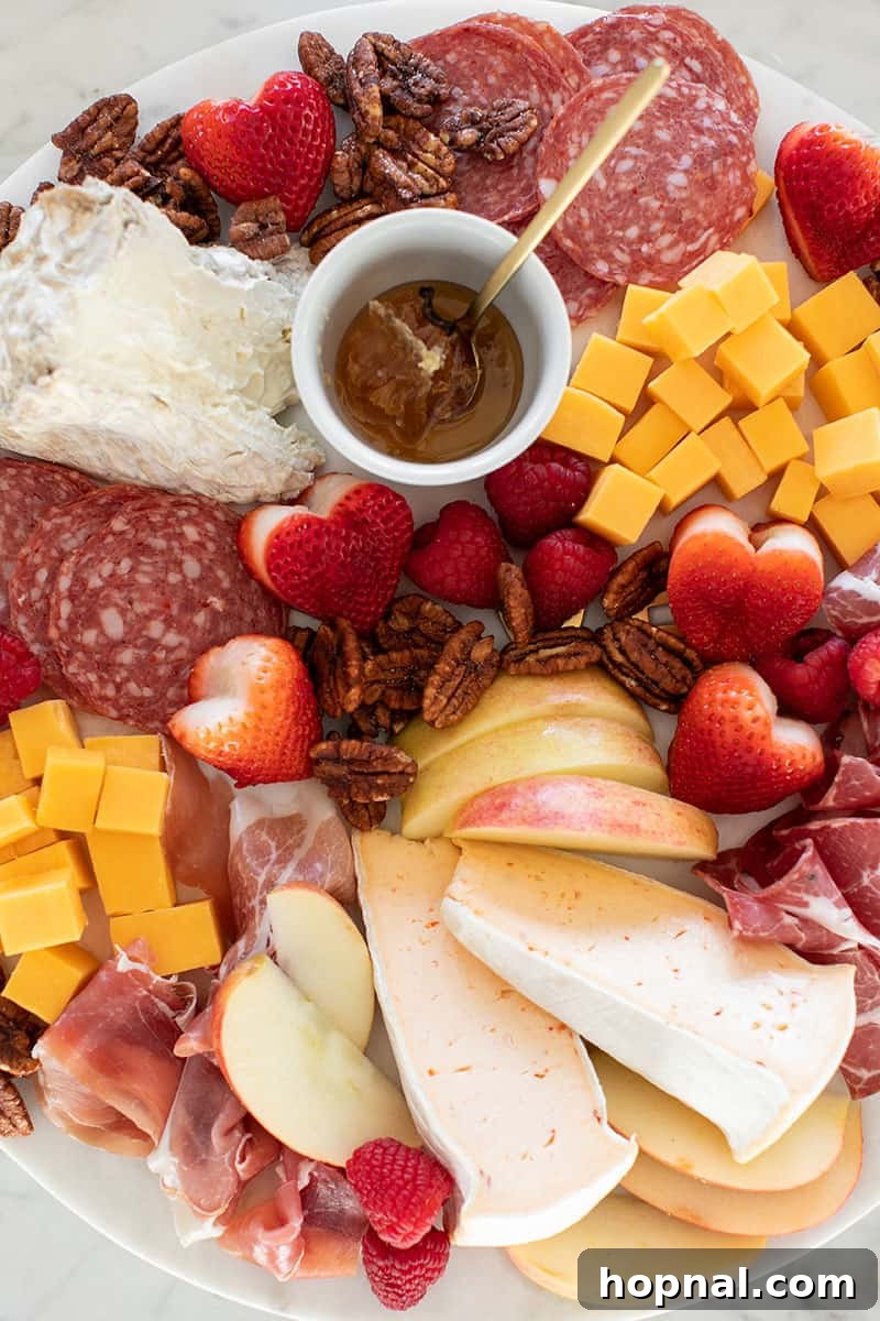 Valentine's Day Sweetheart's Grazing Board 19 A beautifully composed marble platter showcasing a delightful assortment of gourmet meats and fine cheeses, arranged for a sophisticated and inviting spread.