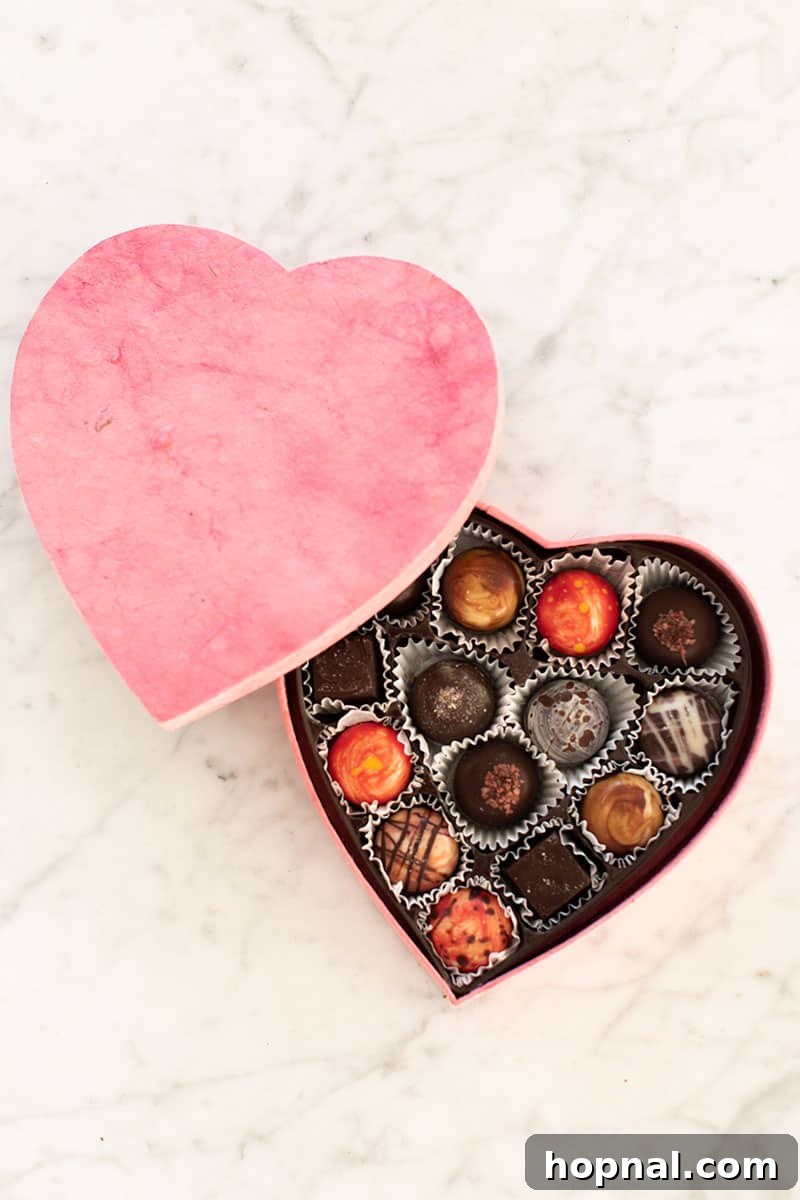 Valentine's Day Sweetheart's Grazing Board 5 Exquisite chocolate truffles elegantly presented in a heart-shaped pink box, poised to be a delightful addition to any Valentine's Day dessert platter, adding a touch of gourmet indulgence.