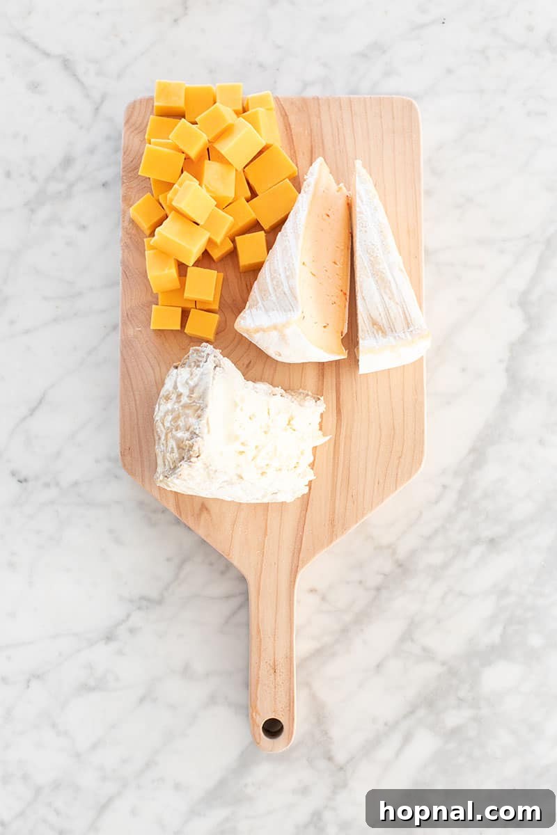 Valentine's Day Sweetheart's Grazing Board 10 A sophisticated arrangement of three distinct types of cheese on a rustic wooden board, showcasing variety in texture and color, perfect for a gourmet tasting.