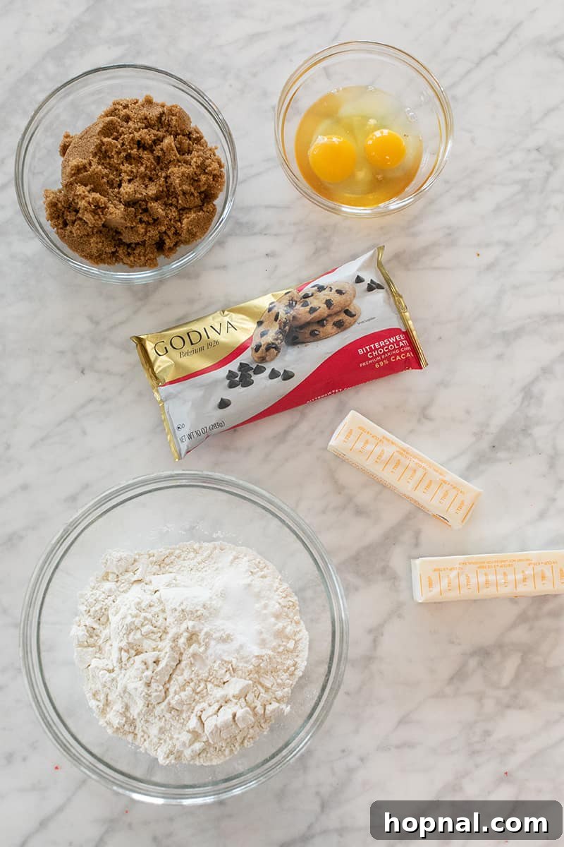 Your Secret to Irresistible Blondies 5 Brown sugar, egg, butter, flour and chocolate chips on a marble table - baking powder, large bowl
