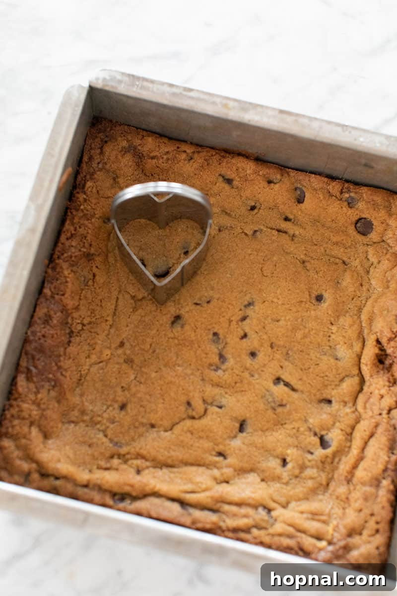 Your Secret to Irresistible Blondies 10 Blondies in a pan with a heart shaped cookie cutter - white chocolate chips, cool completely