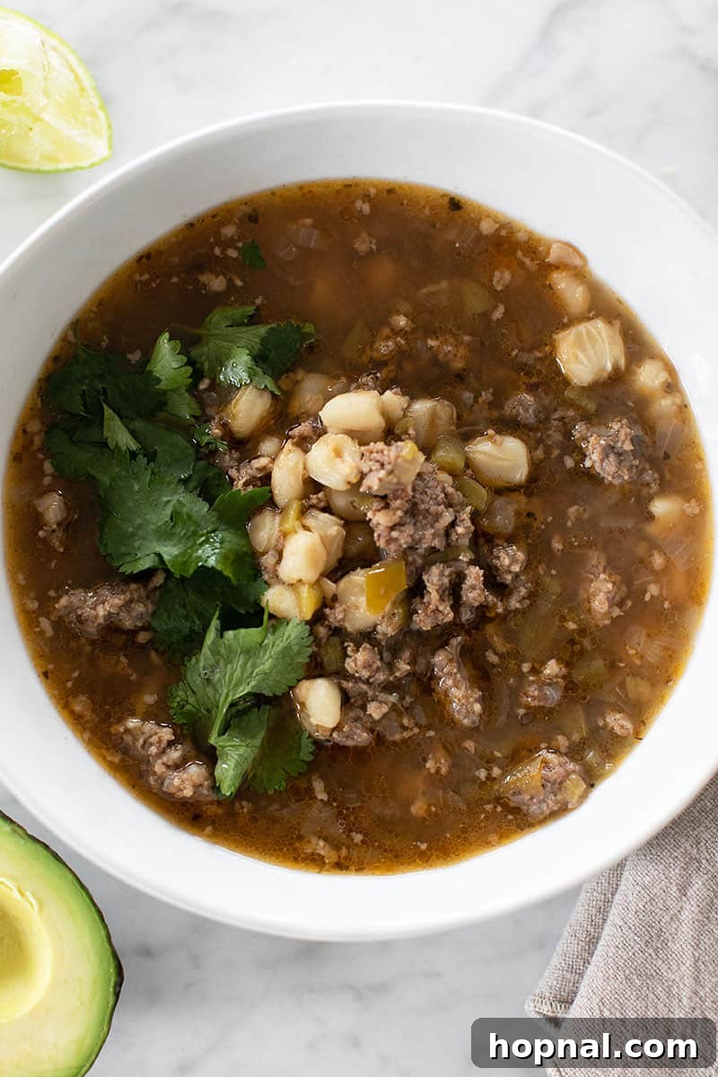 Hominy Soup The Ultimate Winter Comfort 12 Easy pozole soup served in a bowl, with a side of tortilla chips, ready for dipping and enjoying.