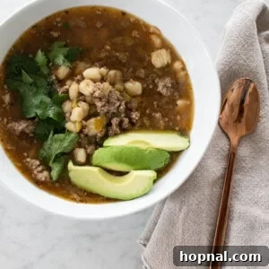 A bowl of Easy Hominy Soup, garnised with cilantro and avocado