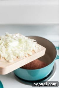 Adding chopped onions into a dutch oven