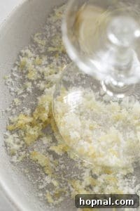 A martini glass rim being dipped into lemon-infused sugar, creating a beautiful and flavorful sugared rim.