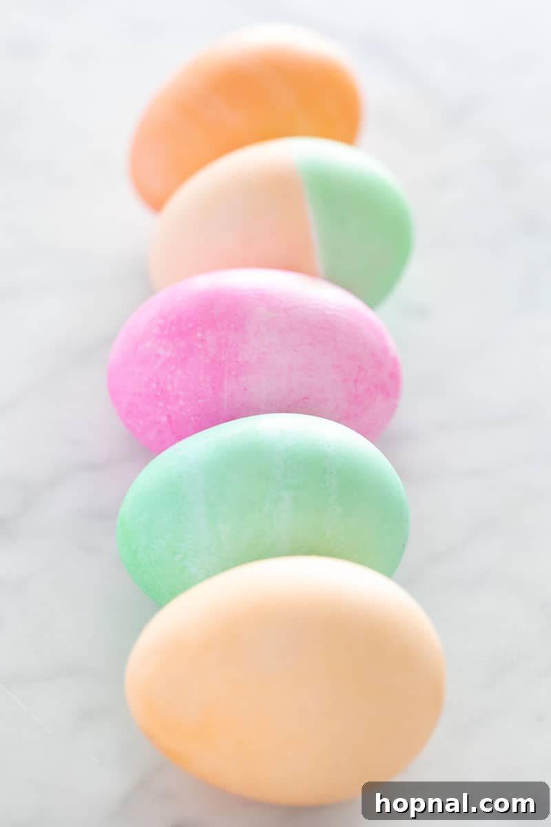 Mastering Easter Egg Dyeing and Design 3 Colored Easter eggs in a row on a marble table.