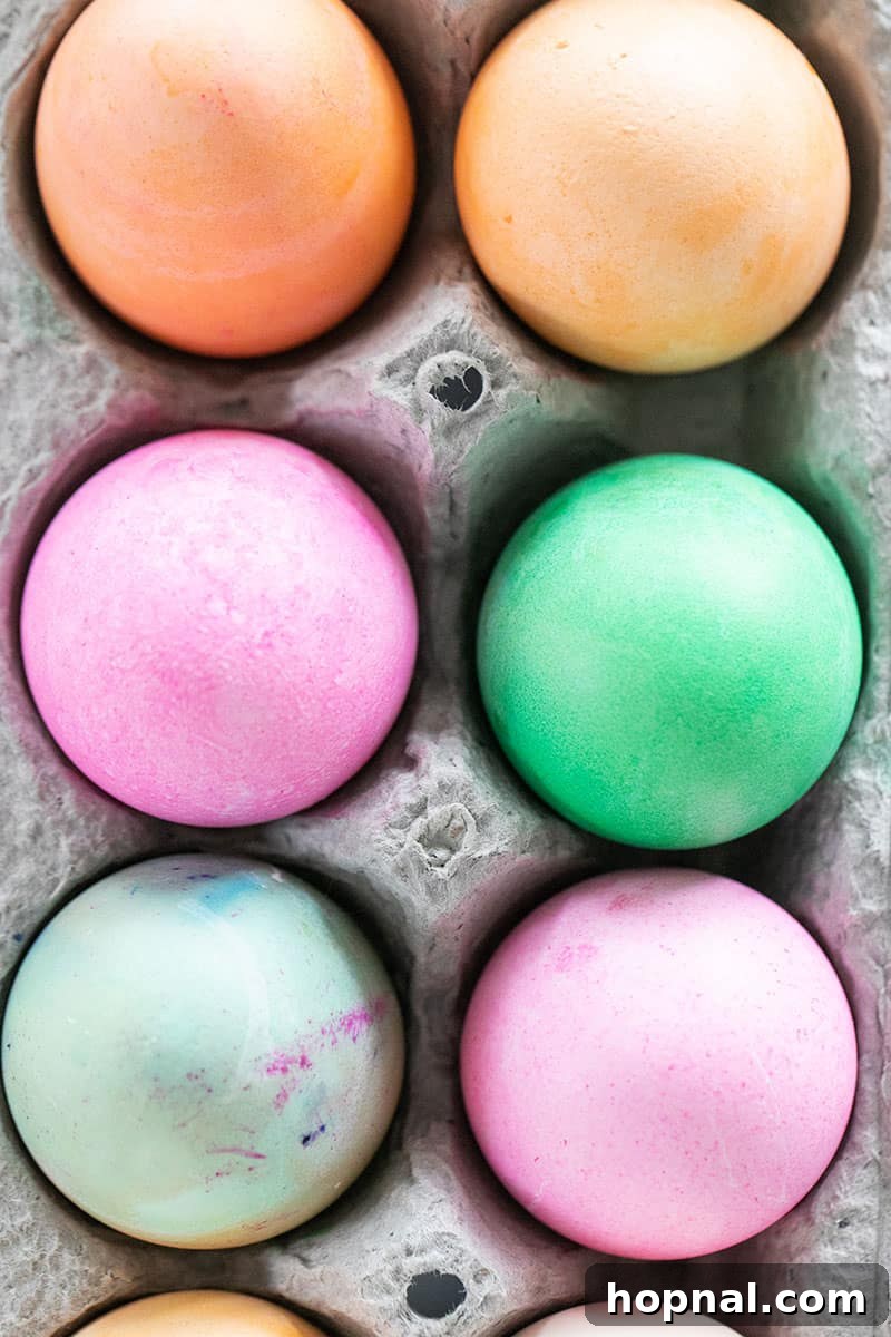 Mastering Easter Egg Dyeing and Design 4 Colored Easter eggs in a carton.