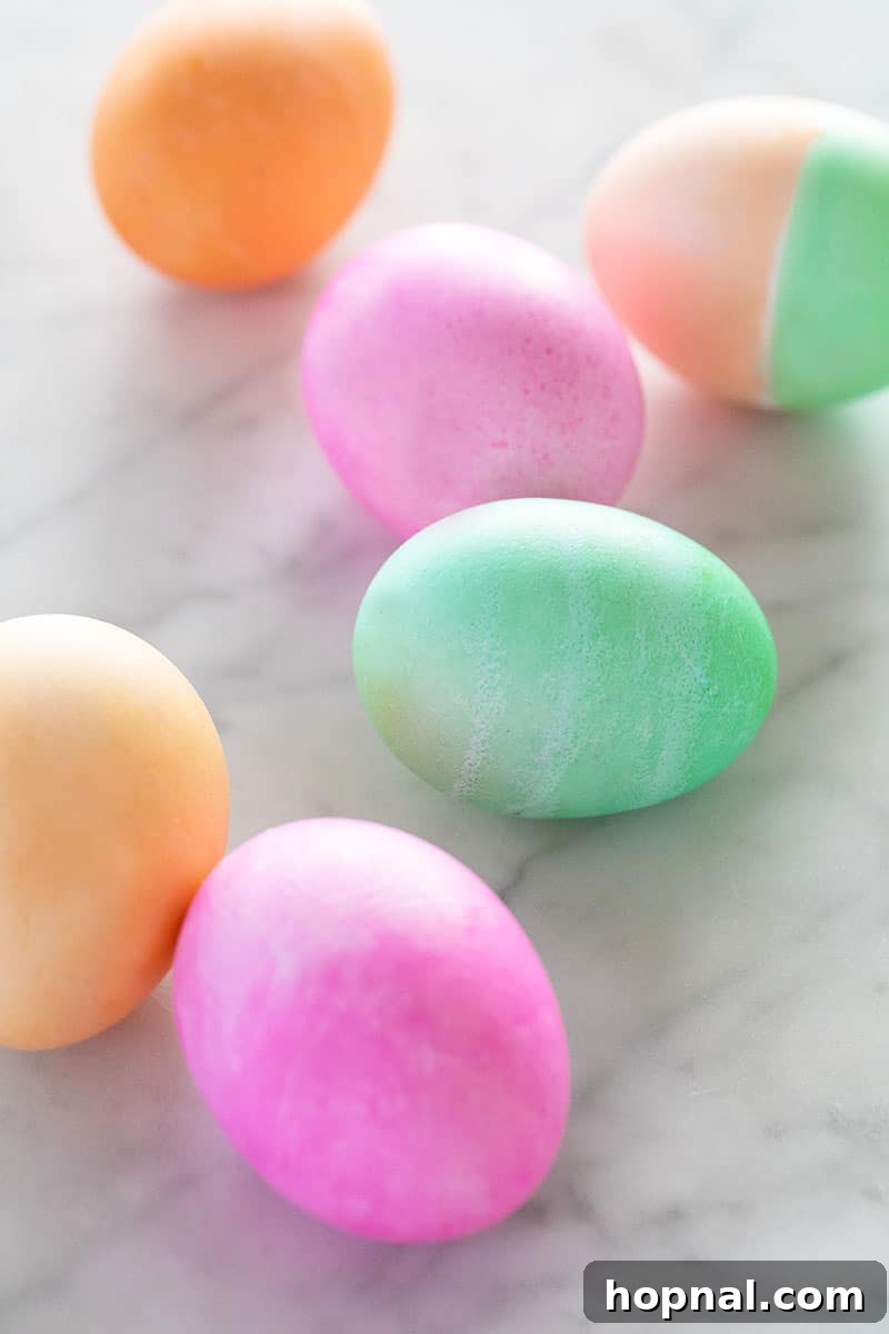 Mastering Easter Egg Dyeing and Design 5 Pink, orange and green Easter eggs in a table.