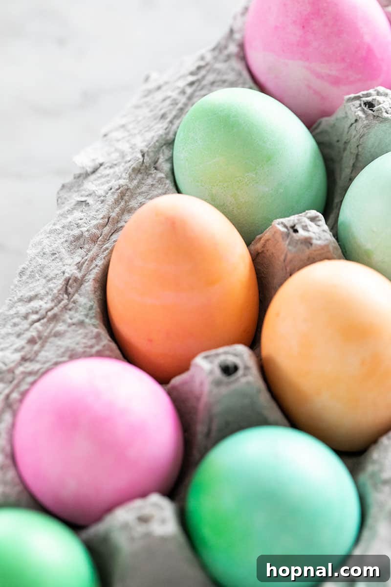 Mastering Easter Egg Dyeing and Design 7 Orange, green and pink dyed Easter eggs in a carton.