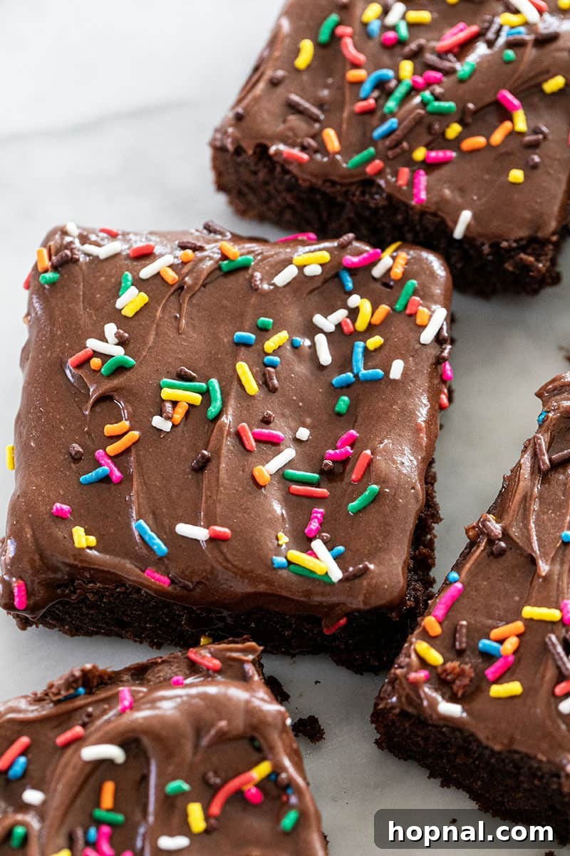 The most delicious homemade brownies, featuring a rich, fudgy texture, topped with a creamy sour cream frosting and colorful sprinkles, ready to be enjoyed.