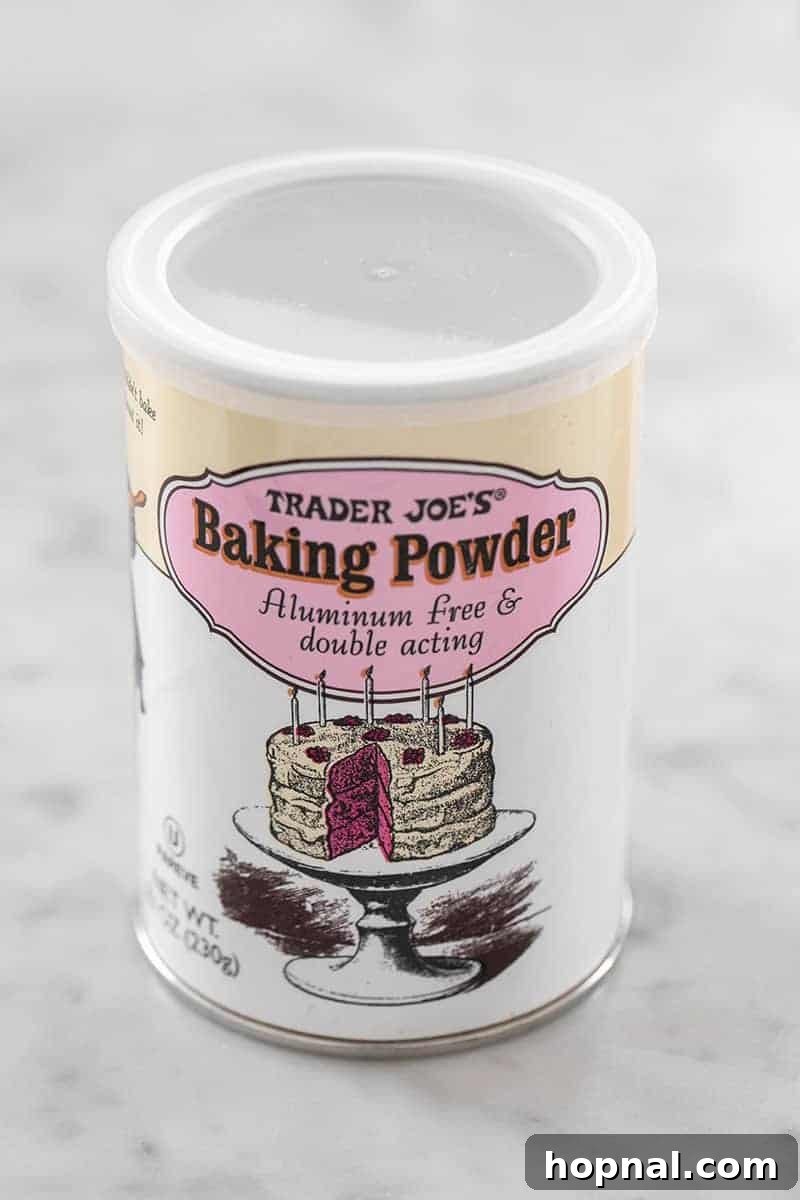 A container of Trader Joe's Baking Powder on a wooden surface.