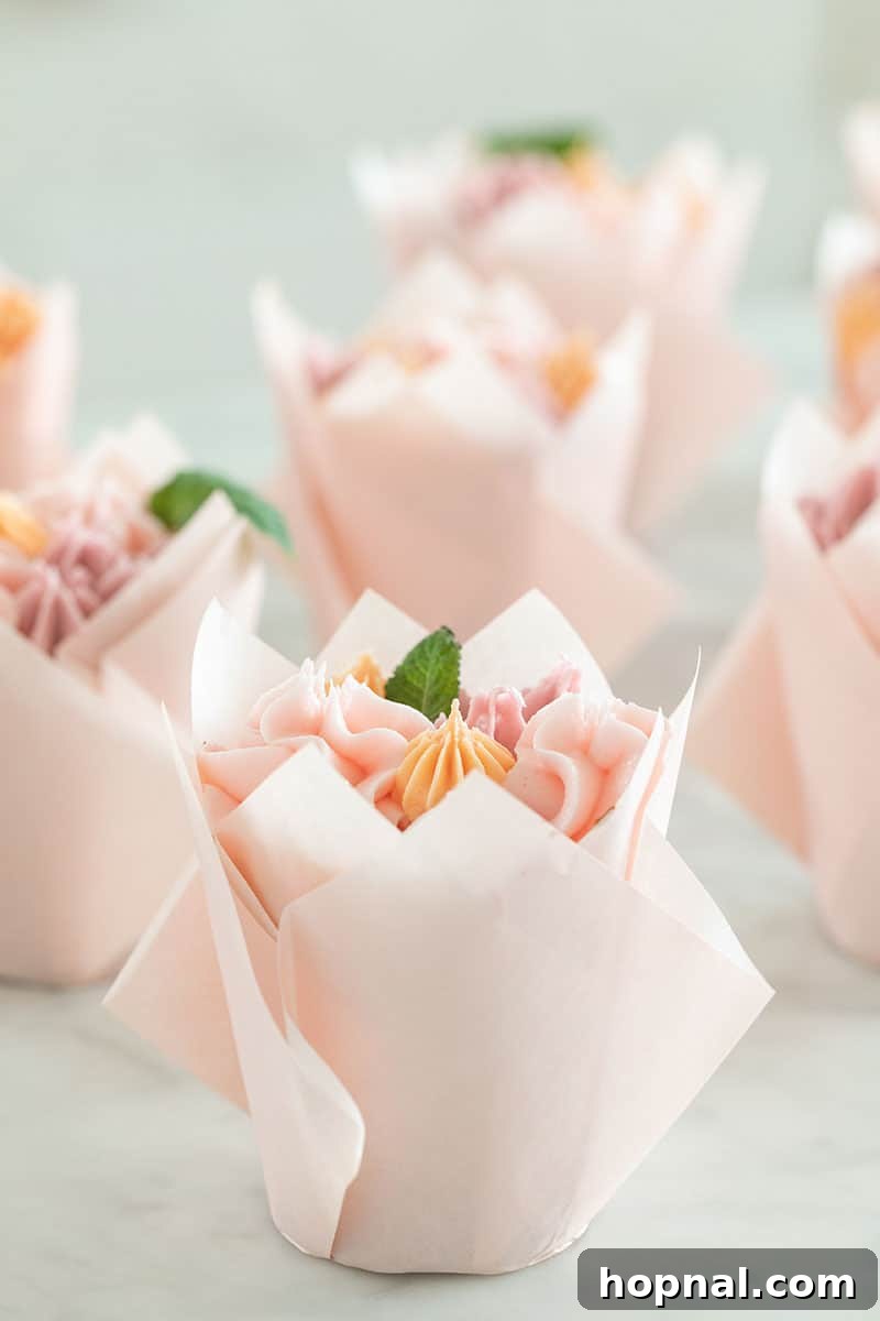 A grand display of a completed cupcake flower bouquet, featuring a variety of colorful buttercream flowers in tulip wrappers.