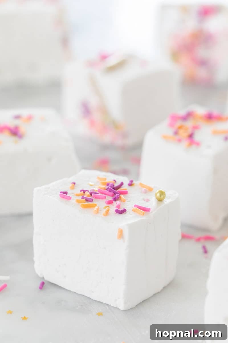 Püfür Püfür Ev Yapımı Marshmallow Sırları 12 A vibrant close-up of fluffy white homemade marshmallows, playfully topped with a shower of colorful sprinkles, creating an inviting and festive look for a sweet treat.
