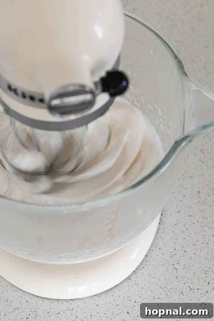 Püfür Püfür Ev Yapımı Marshmallow Sırları 7 The hot sugar syrup is carefully poured into the bowl of a stand mixer, where it combines with the bloomed gelatin and is vigorously whipped into a thick, glossy, and remarkably fluffy marshmallow base.