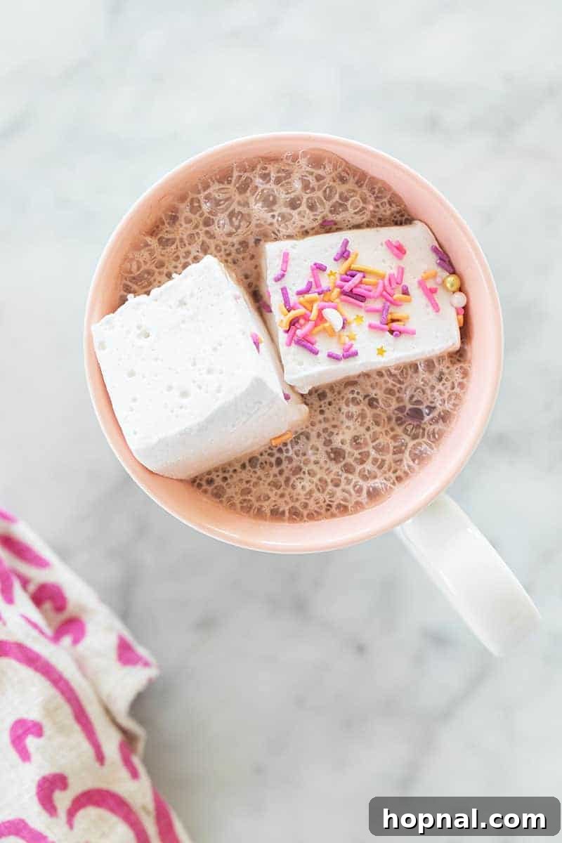 Püfür Püfür Ev Yapımı Marshmallow Sırları 10 A close-up shot of fluffy homemade marshmallows delicately floating on top of a rich, steaming cup of hot chocolate, ready to melt into a creamy, luxurious indulgence. The perfect winter treat.