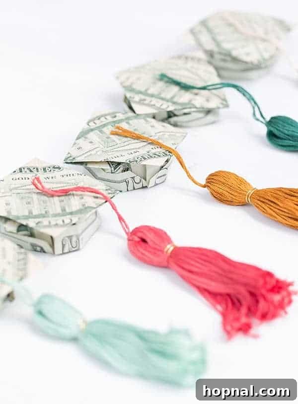 Collection of intricate origami money graduation hats with small tassels, presented as creative graduation gifts.