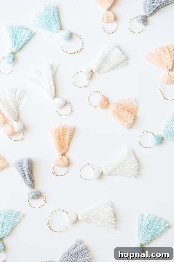 Close-up of colorful DIY tassel wine charms attached to wine glass stems, adding festive decor to a graduation party.