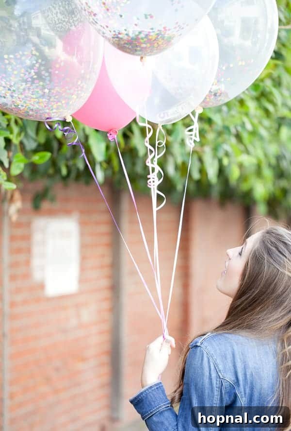 A person holding a large clear balloon filled with confetti and money, creating a fun and surprising graduation gift idea.