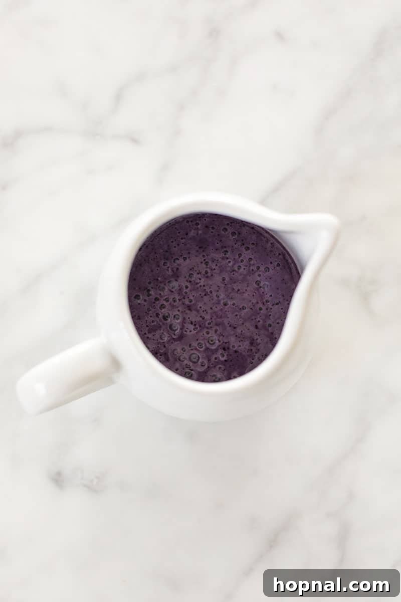 Smooth, rich purple blueberry popsicle mixture in a blender, perfectly prepared for the final layer.