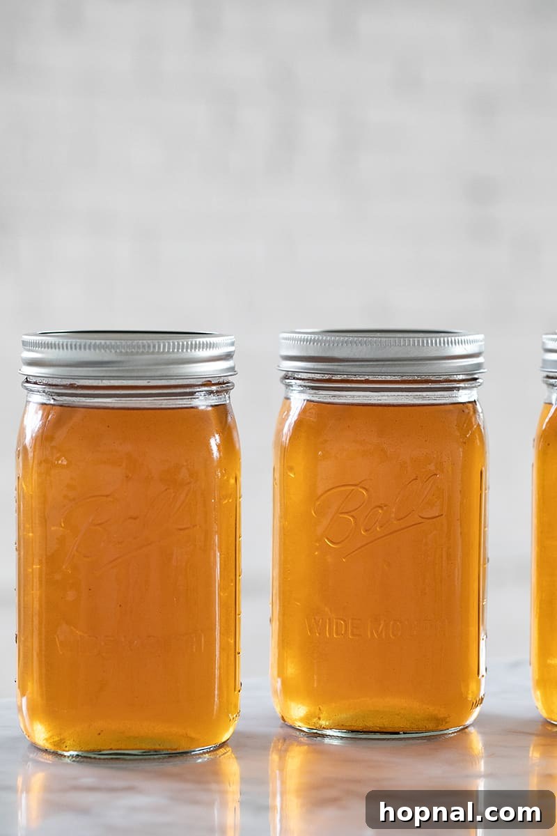 Multiple Ball jars of apple pie moonshine with their lids securely fastened, ready for storage.