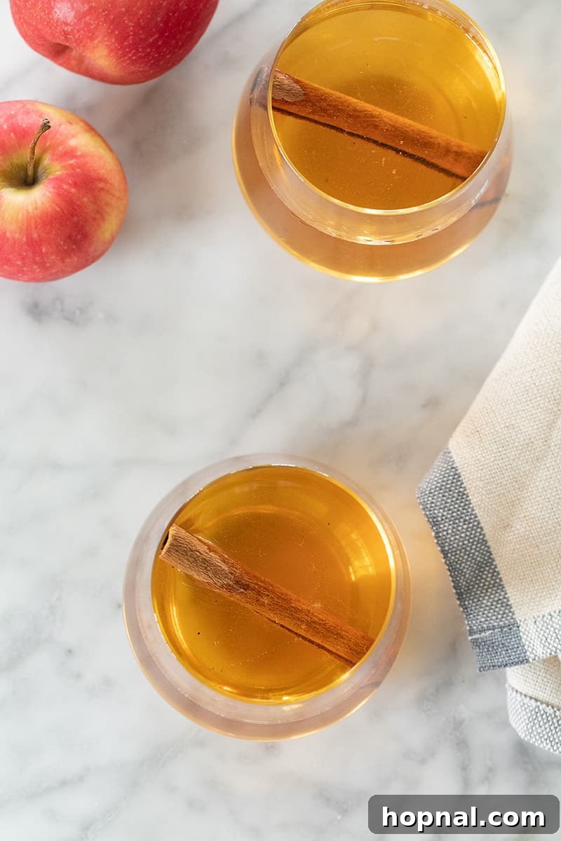 A pristine jar of apple pie moonshine, elegantly placed on a marble tabletop, ready to be enjoyed.