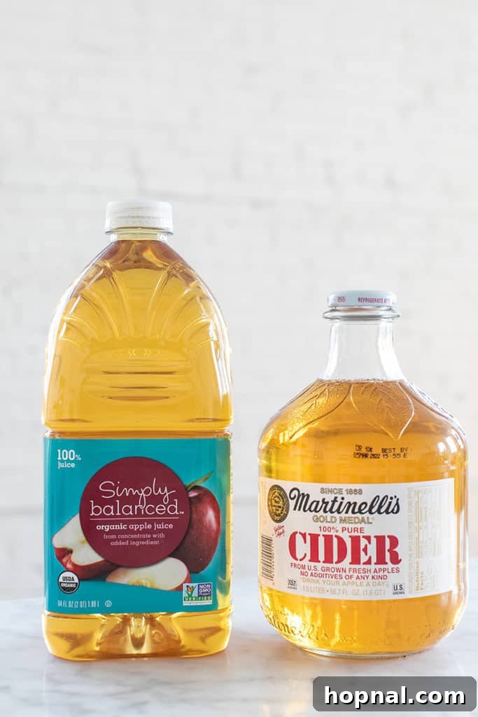 Ingredients for apple pie moonshine laid out on a table: apple juice, apple cider, sugars, and spices.
