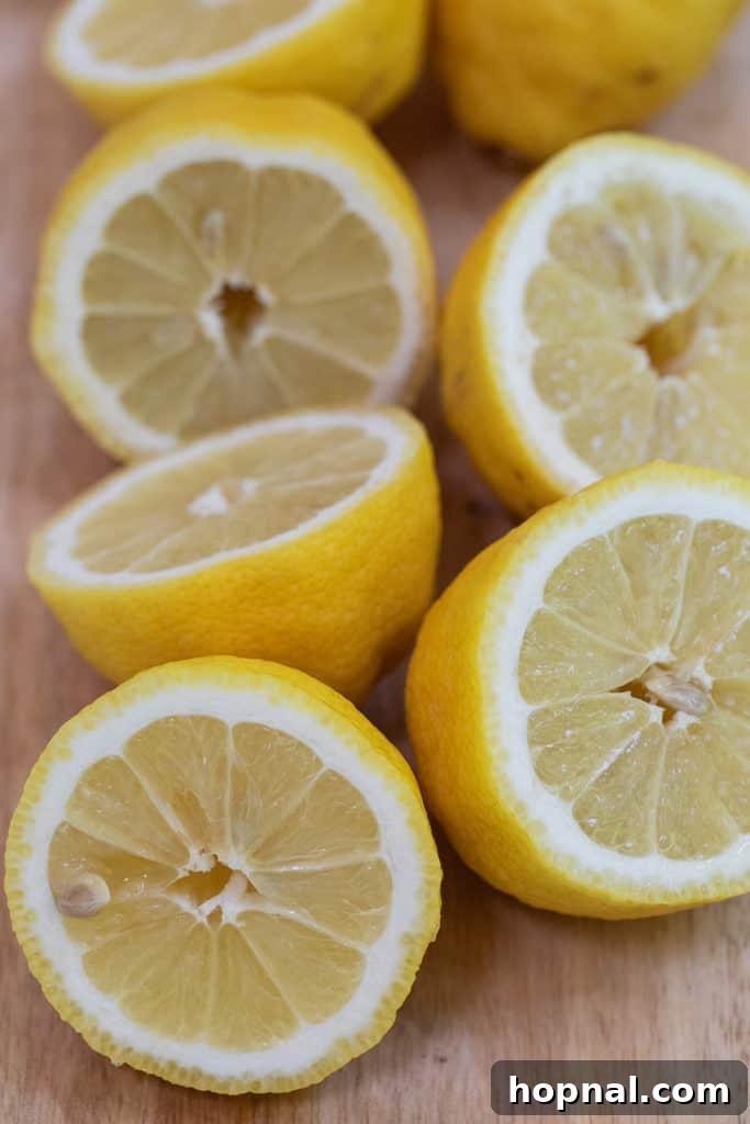 Fresh lemons, perfectly sliced and ready for squeezing, showcasing their bright yellow color and juicy texture.