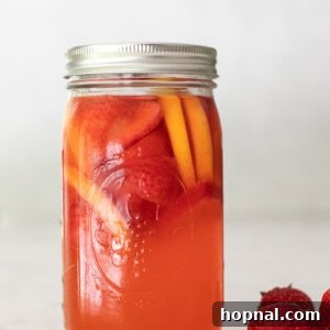 A glass of homemade strawberry lemonade garnished with fresh fruit, invitingly presented.
