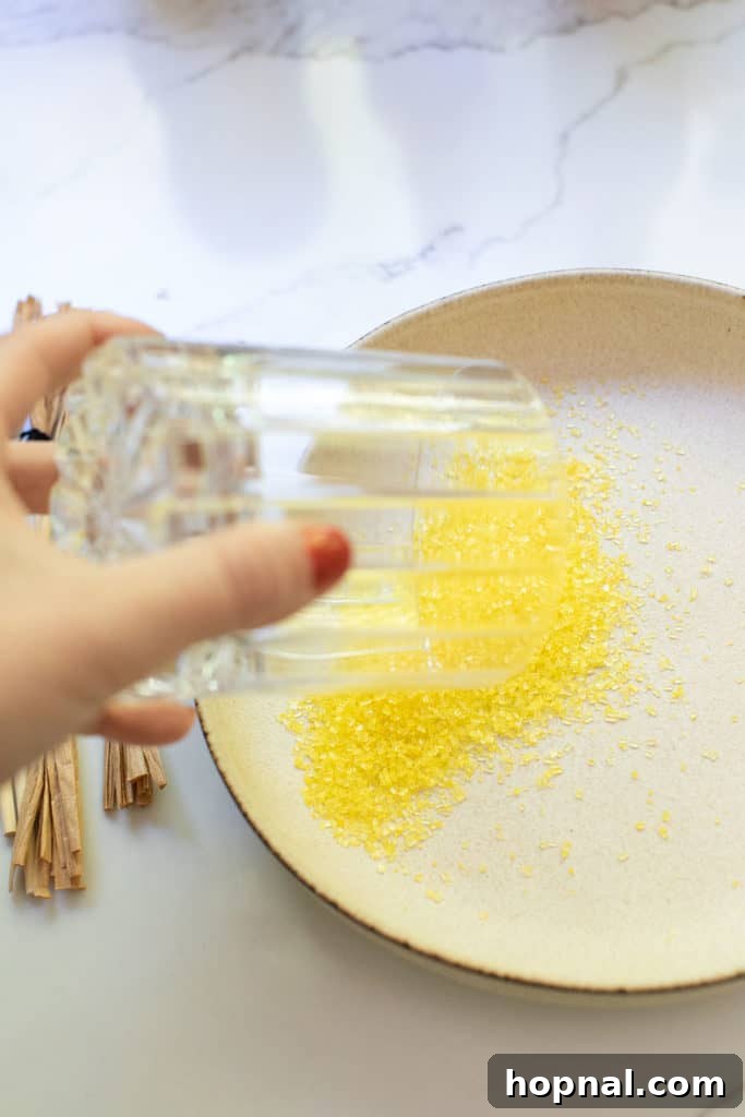 Yellow sprinkles adhering to the rim of a clear glass, ready for a magical drink.
