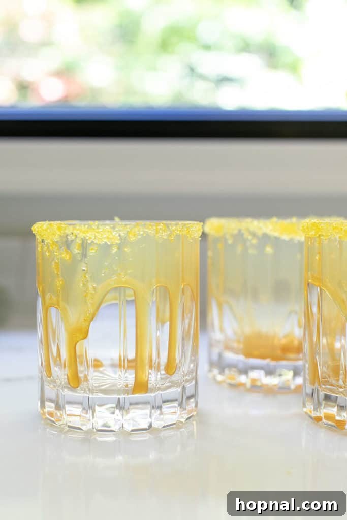 Rich butterscotch sauce gracefully dripping down the interior sides of a glass, preparing for a layered drink.