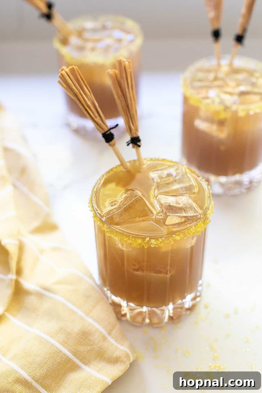 Homemade butterbeer, showcasing its creamy butterscotch and frothy cream soda layers, served in a clear mug.