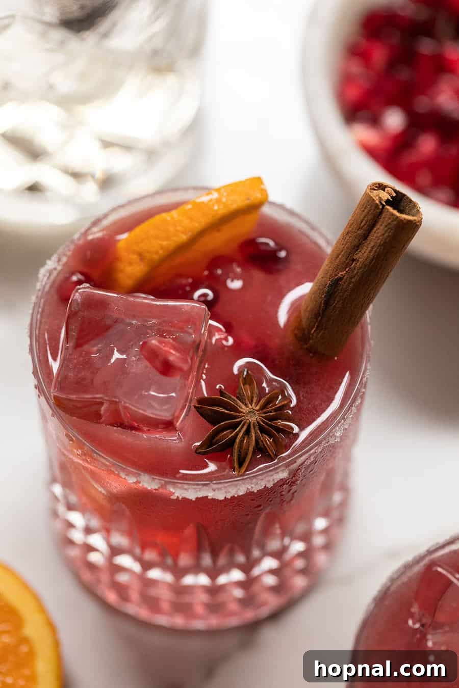 Crimson Spice Margarita 3 Red pomegranate margaritas with cinnamon stick, orange slice and star anise.