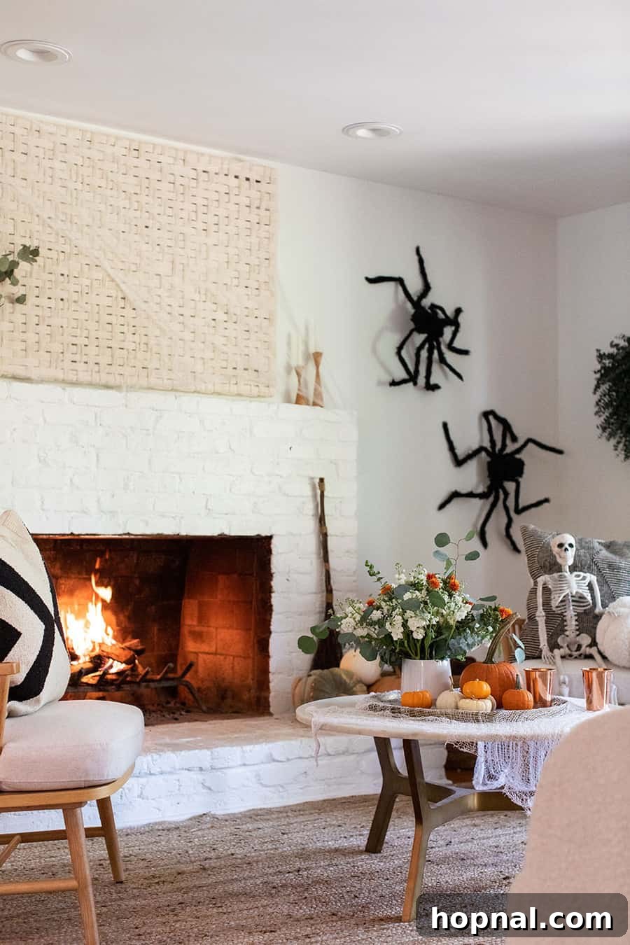 Fireplace adorned with elegant Halloween decorations including pumpkins and skeletal elements
